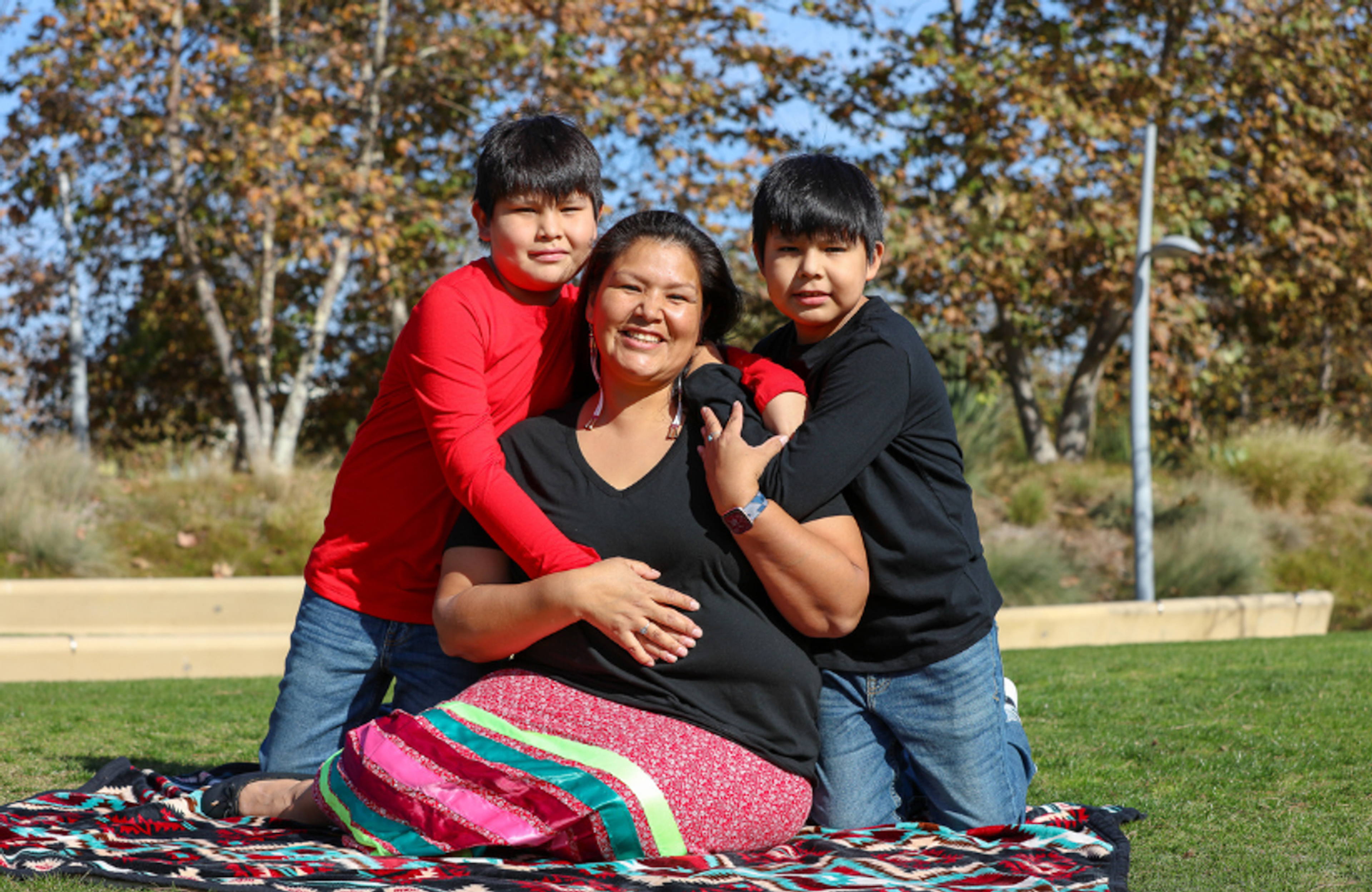 Mom With Two Sons Sitting on Blanket on the Grass.