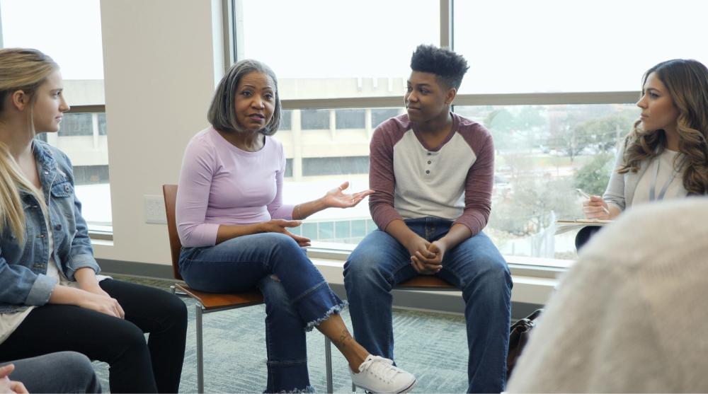 Mom and son sitting in circle at group therapy.