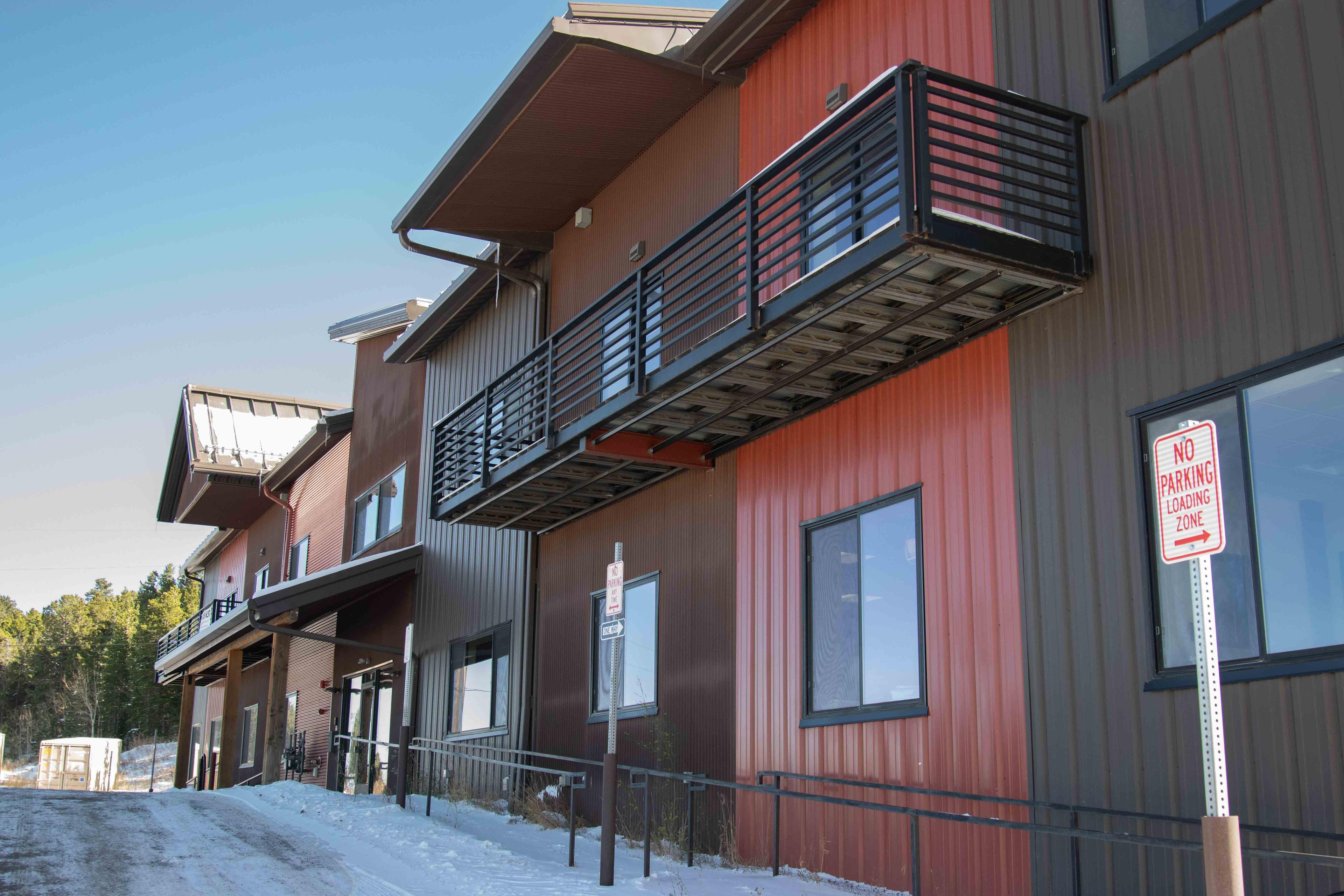 Nederland Office Outside: red and brown sheet metal material. Sidewalk ramp to door entrance.