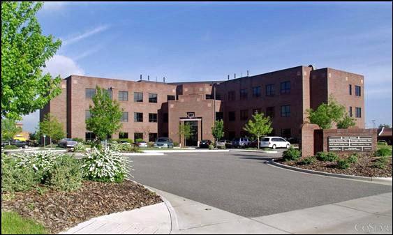 External photo of Dixon offices. Three story brick building structured in an angled shape. 