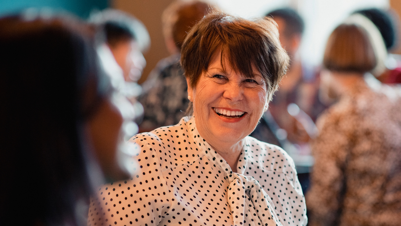 Connecting Clients to Additional Care Woman Smiling  at Another Woman Talking 