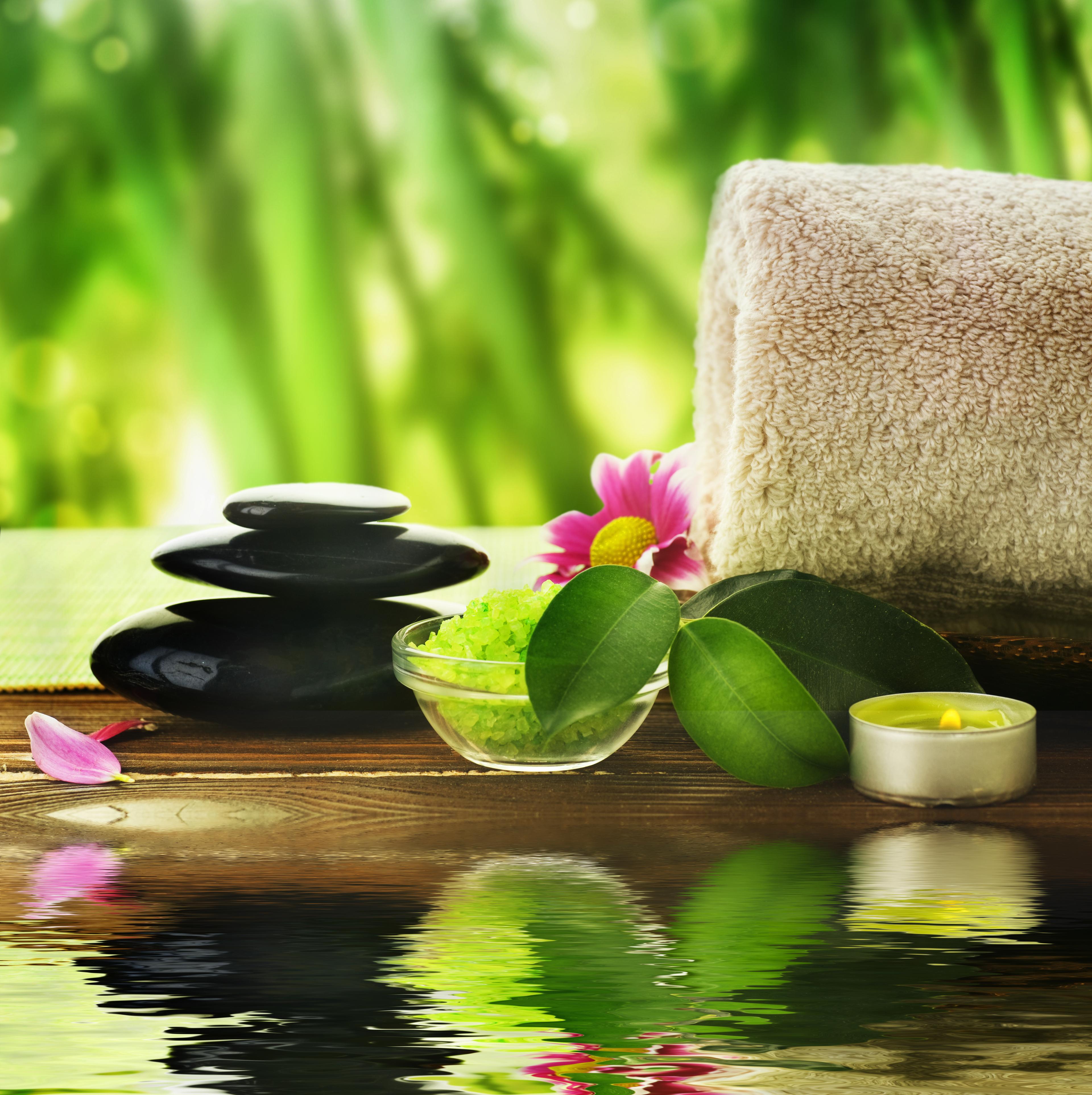 Stress Management: Relaxing set up with stones, bath salt, candle, towel, and pink flower.