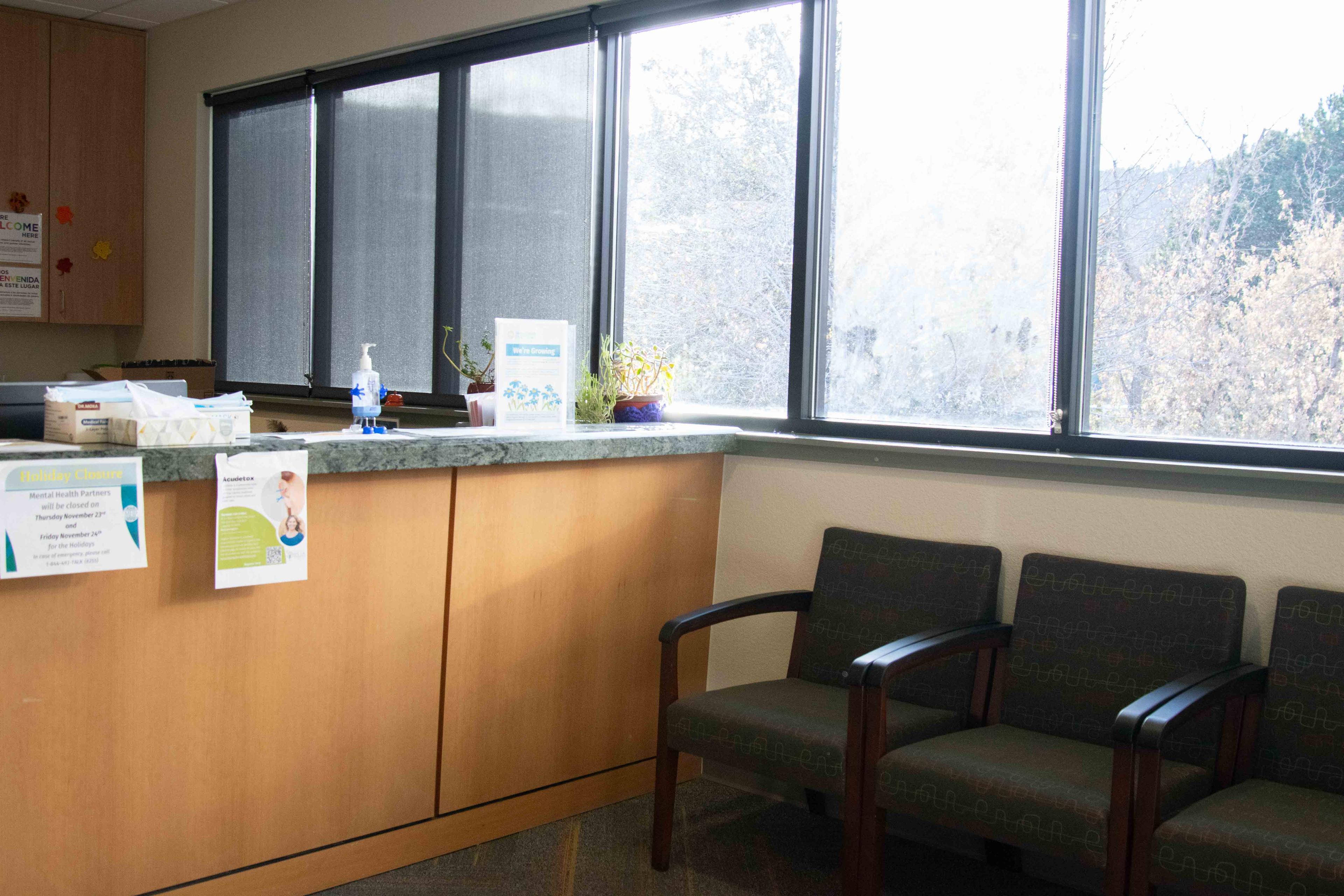 Lobby of Norton building located on the second floor. Row of windows, front desk, and lined up chairs.