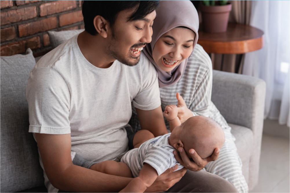 Parents looking at baby smiling.