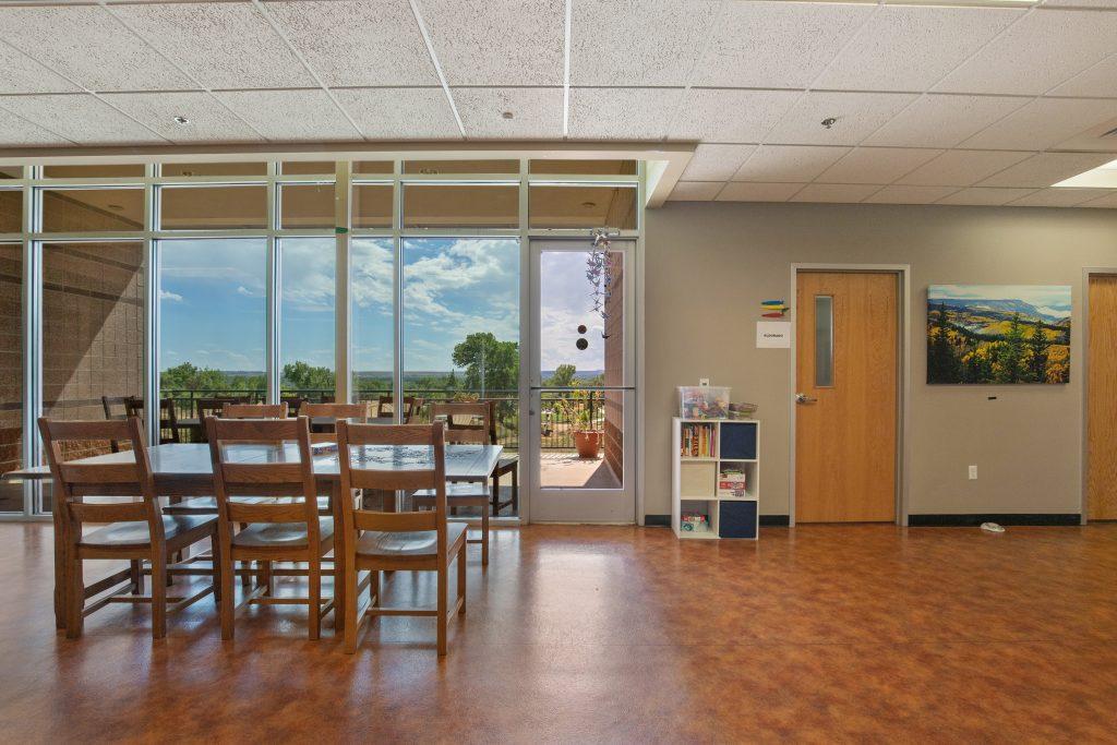 Crisis Center lounge area with table and chairs with large window wall.