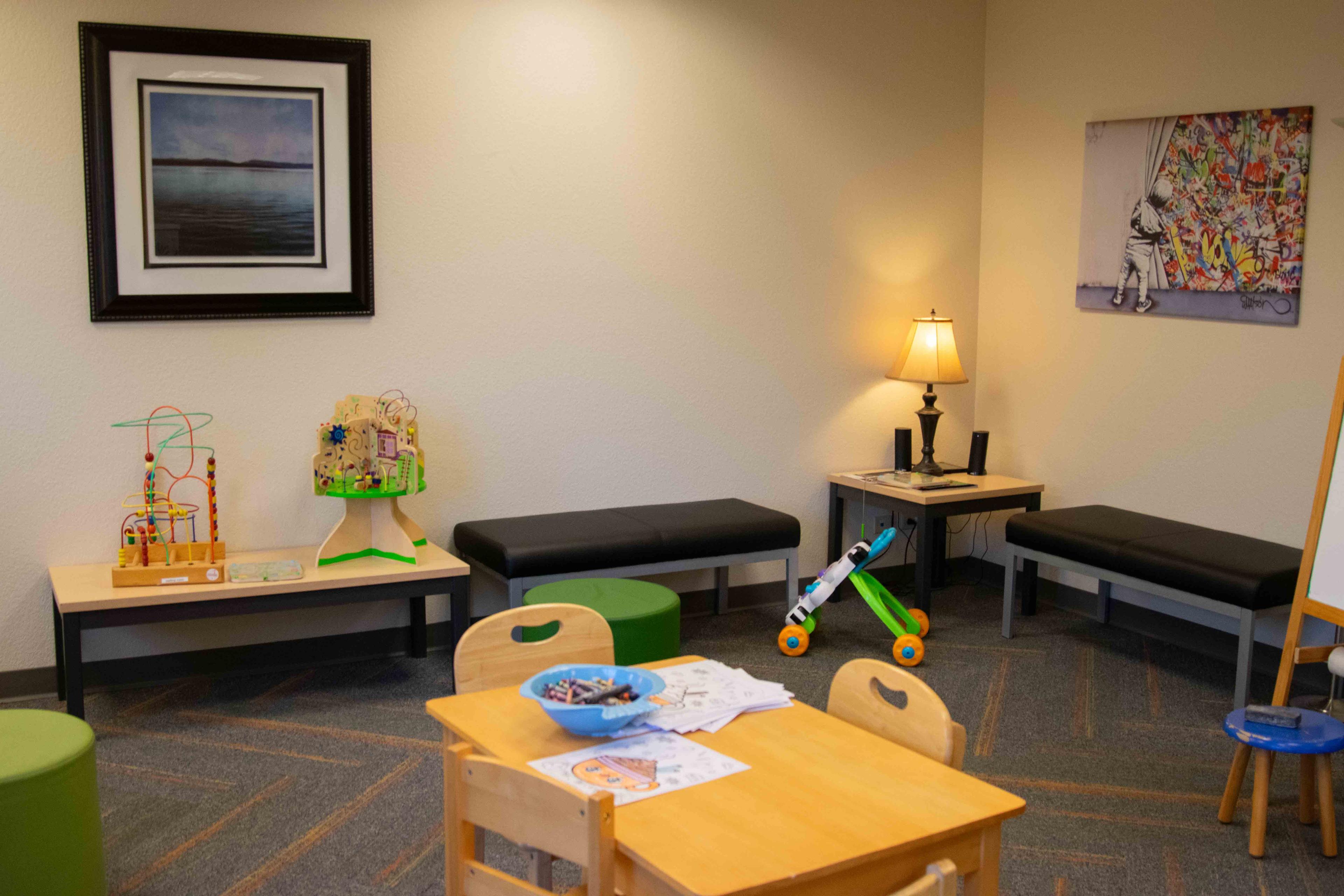 Inside lobby of Norton. Playroom with kids' games and benches along the wall.