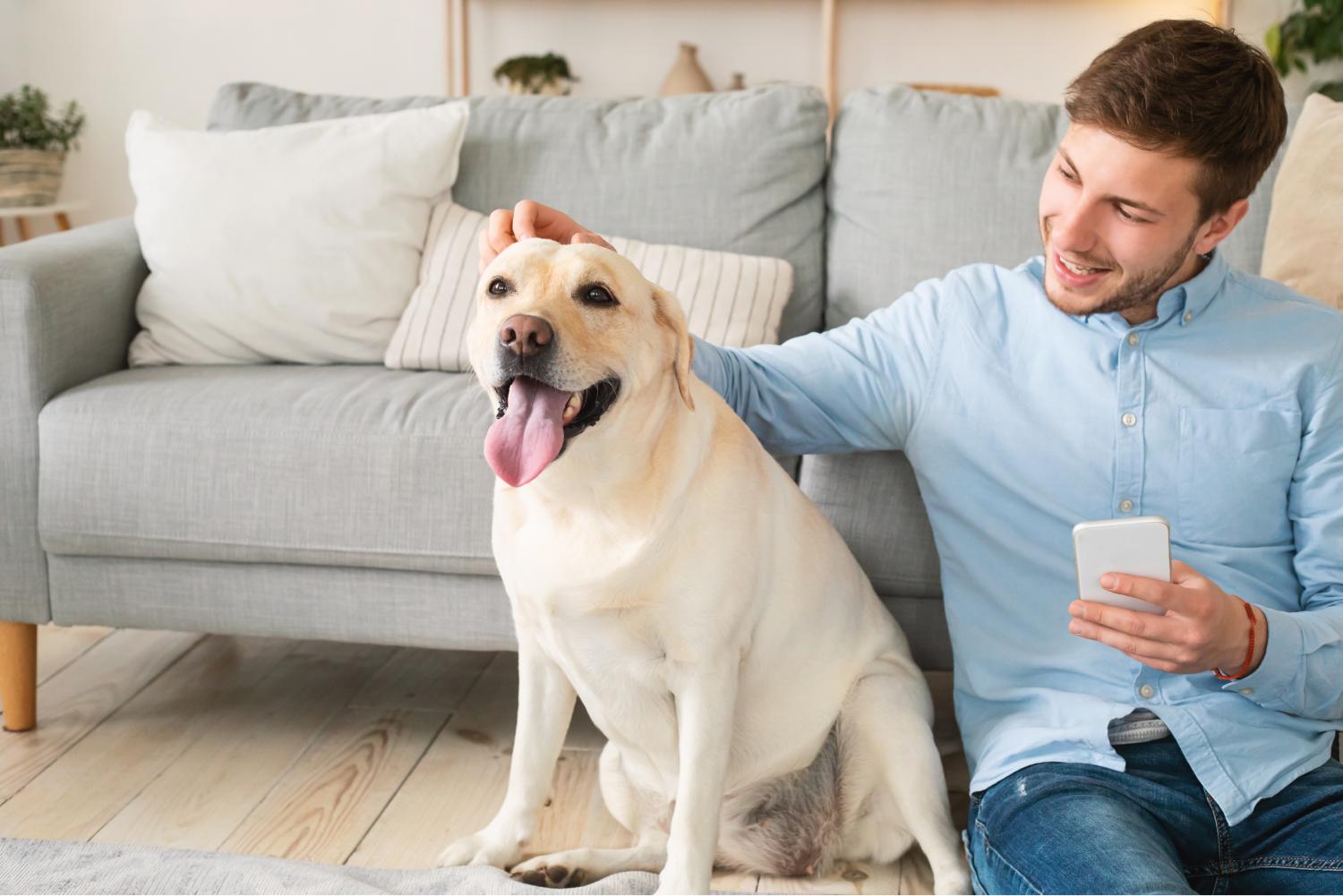 Portrait of man with his dog using mobile phone.