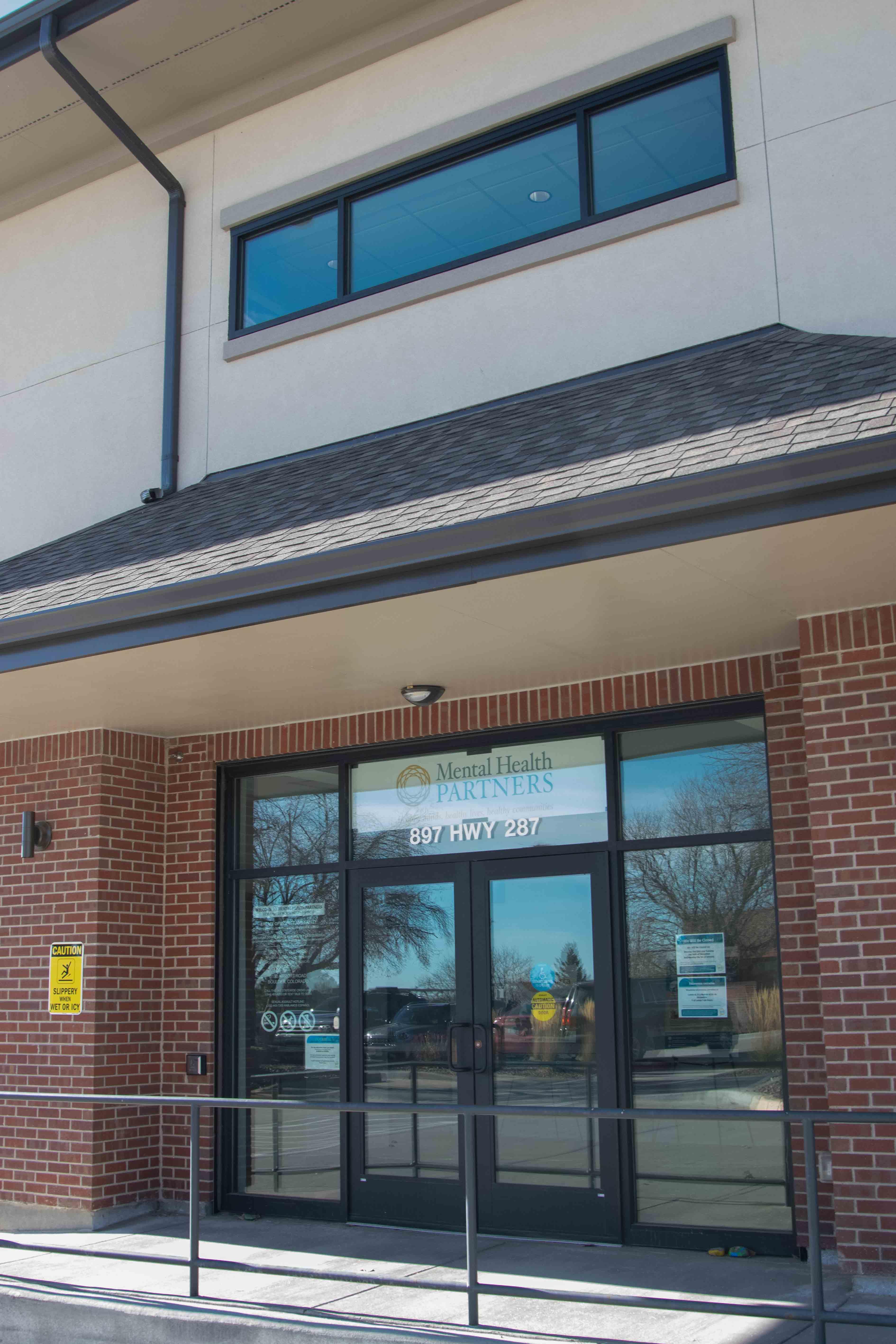 Outside of Broomfield office: large glass doors and brick buildling.